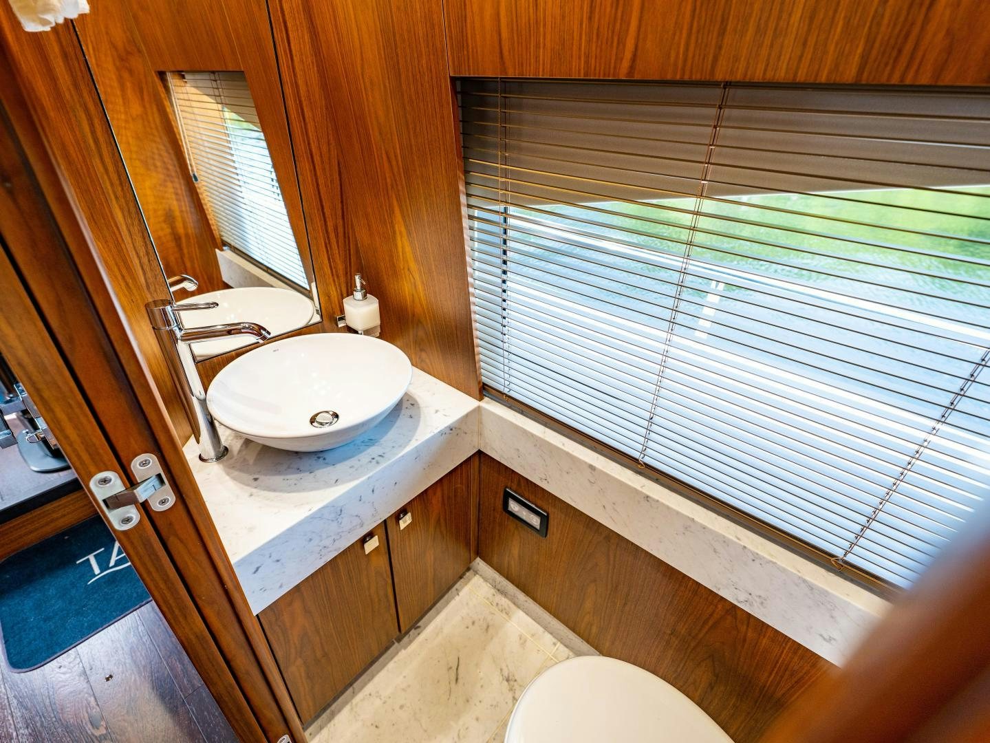 a bathroom with a sink and a window aboard TATIS Yacht for Sale