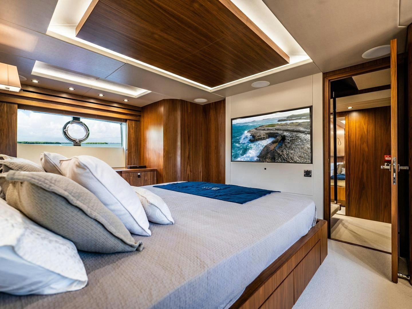 a bedroom with a bed and a mirror aboard TATIS Yacht for Sale
