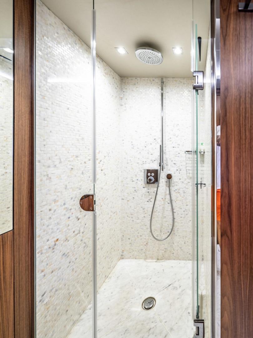 a shower with a white wall aboard TATIS Yacht for Sale