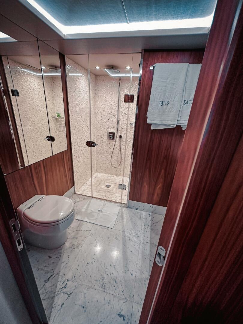 a bathroom with a toilet and a red door aboard TATIS Yacht for Sale