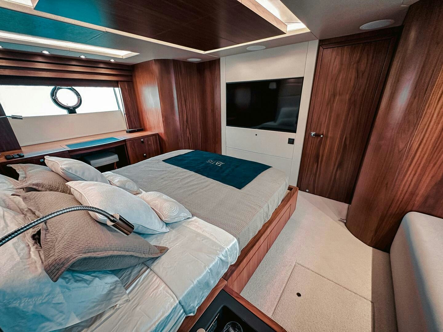 a bedroom with a bed and a wood cabinet aboard TATIS Yacht for Sale