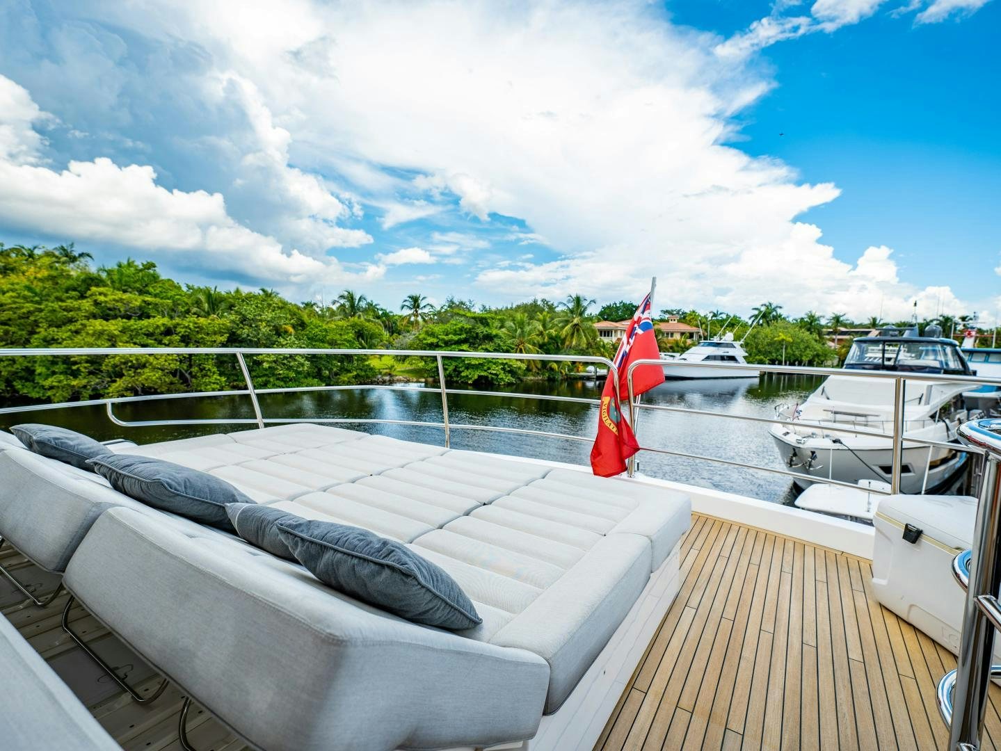a deck with a flag and boats on it aboard TATIS Yacht for Sale