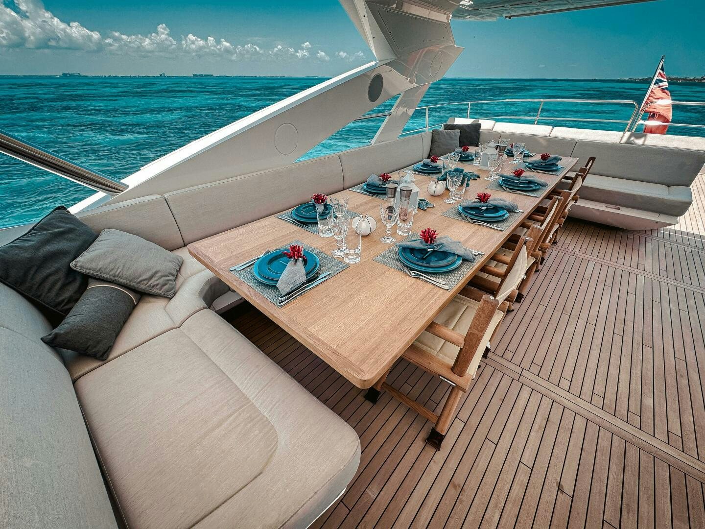 a deck with a table and chairs on it and a large body of water in the background aboard TATIS Yacht for Sale