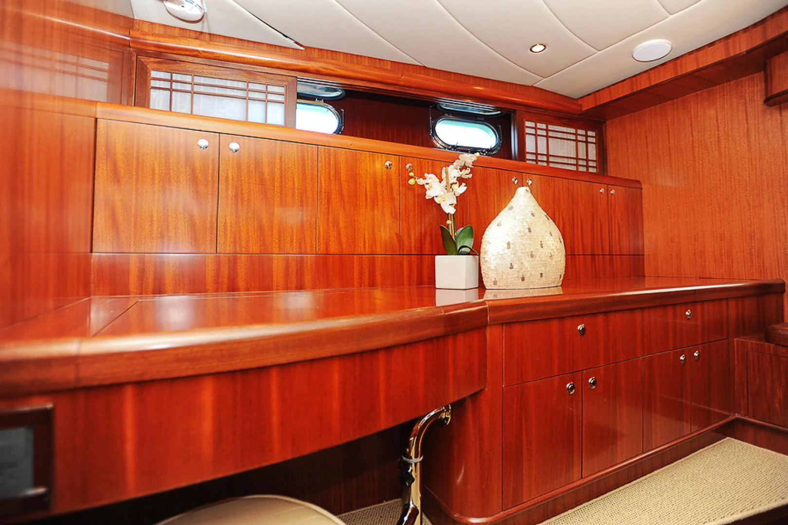 a wooden cabinet with a vase of flowers on it aboard MARANATHA Yacht for Sale