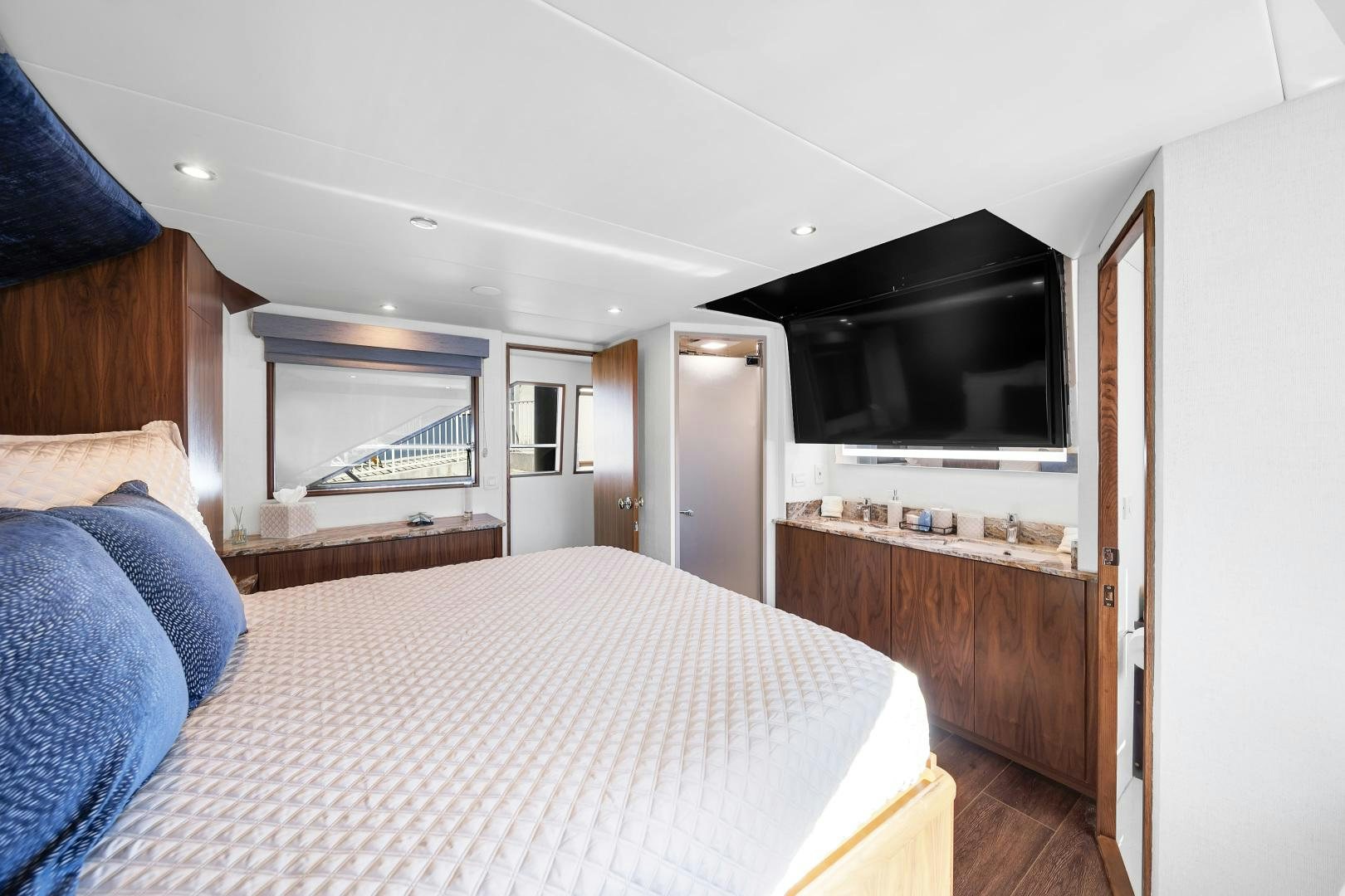 a bedroom with a bed and a television aboard A PLACE IN THE SUN Yacht for Sale