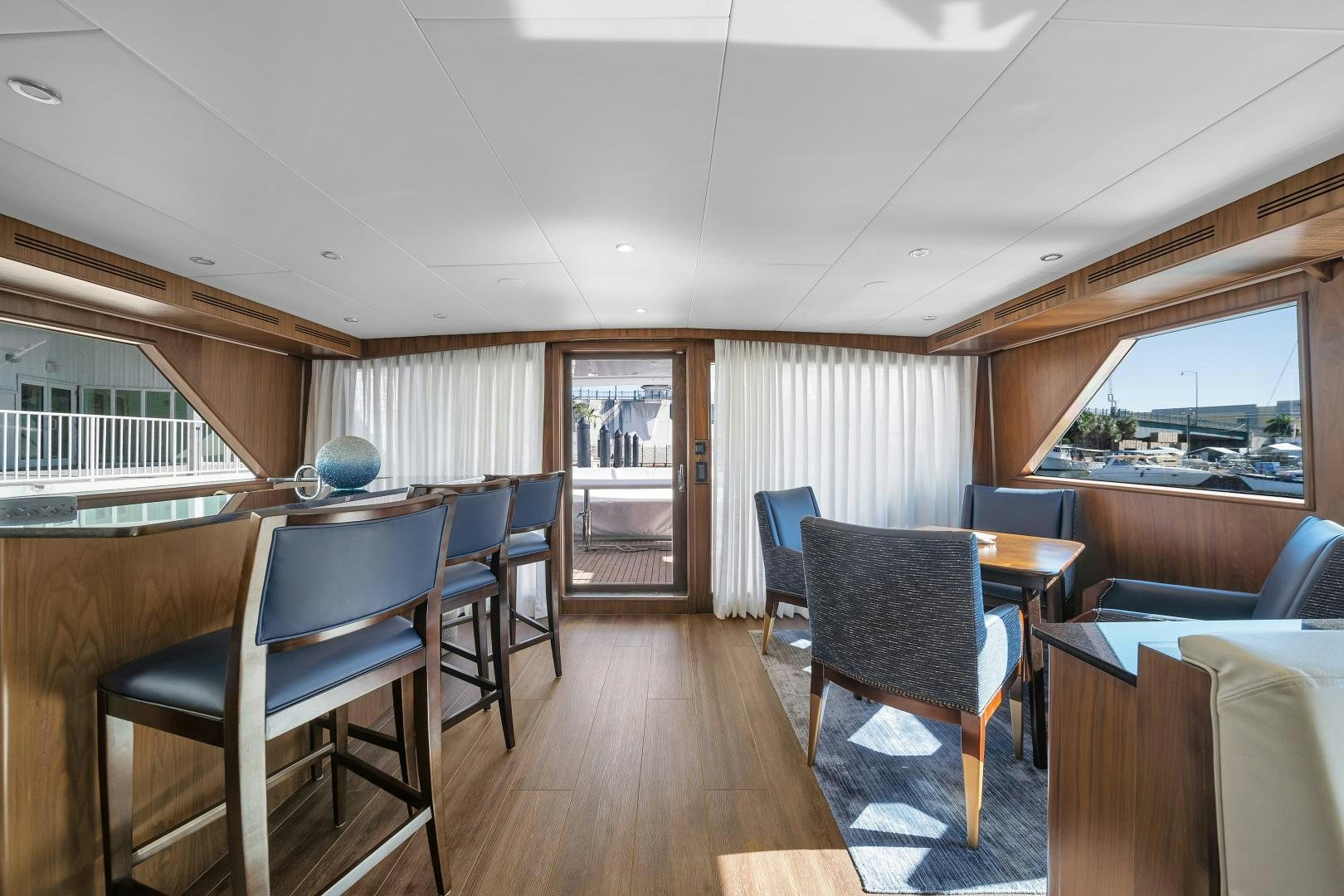a room with a wood floor and chairs and a wood floor aboard A PLACE IN THE SUN Yacht for Sale