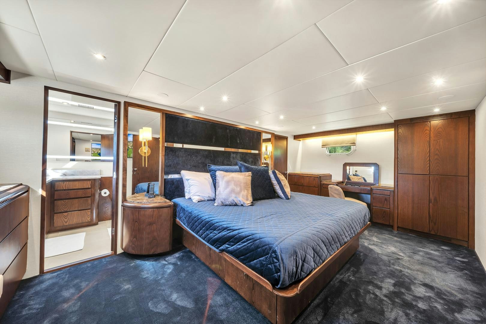 a bedroom with a bed and a mirror aboard A PLACE IN THE SUN Yacht for Sale