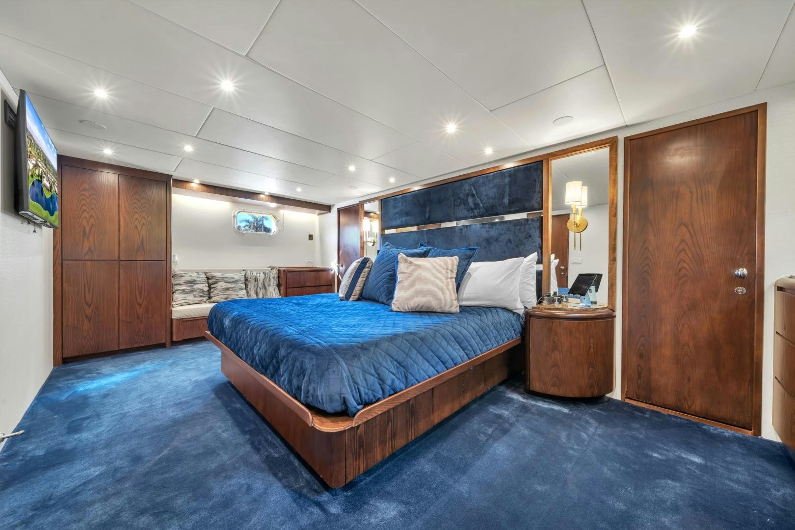 a bedroom with a bed and a wood door aboard A PLACE IN THE SUN Yacht for Sale
