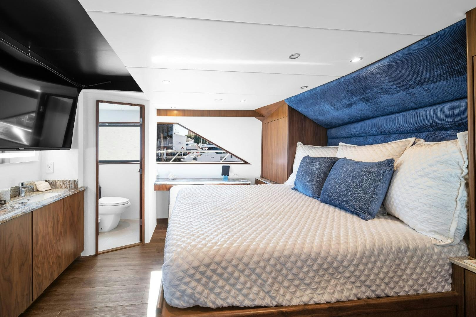 a bedroom with a bed and a window aboard A PLACE IN THE SUN Yacht for Sale