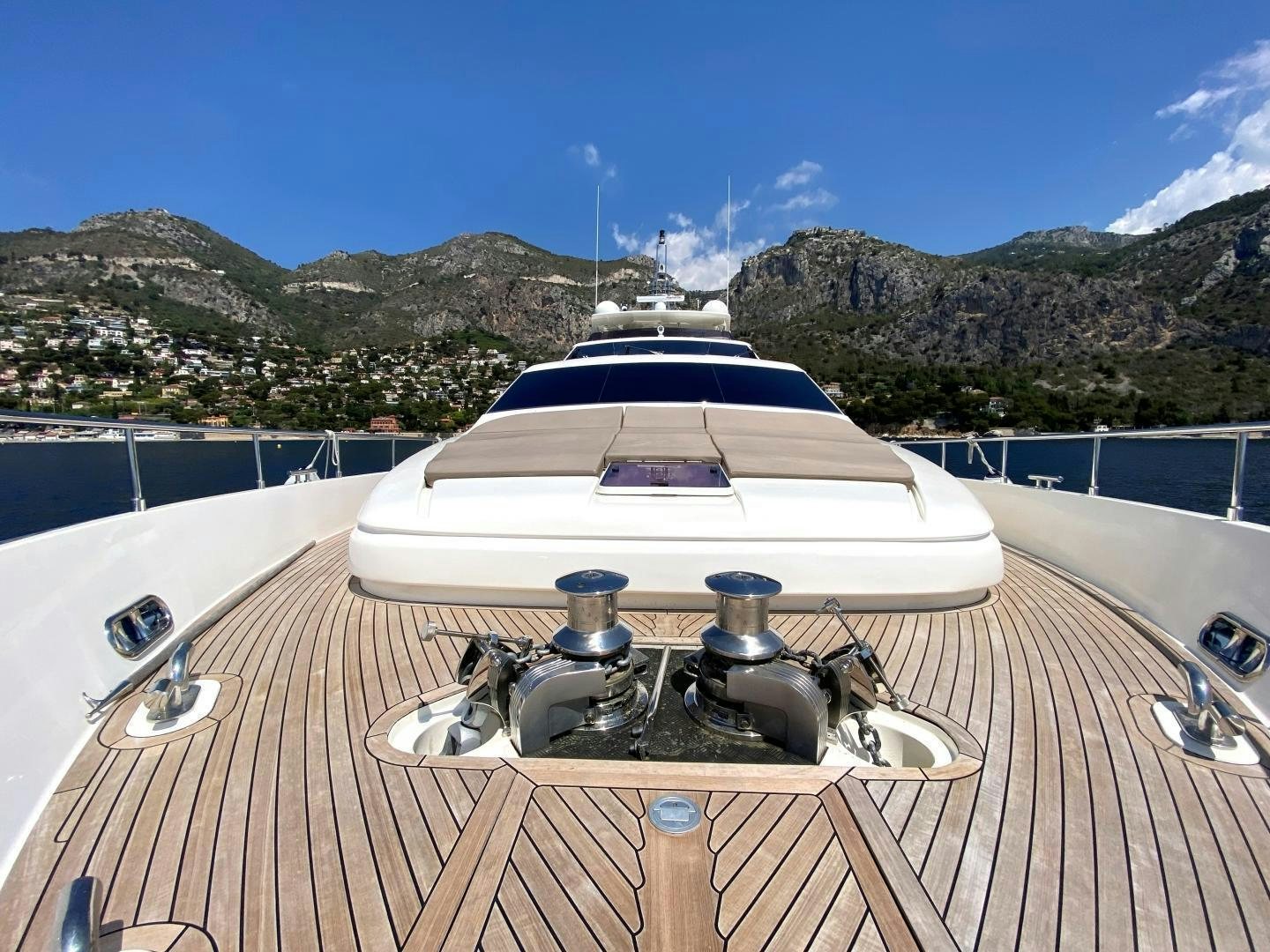 a large white round object on a deck with a view of mountains and water aboard MELI Yacht for Charter