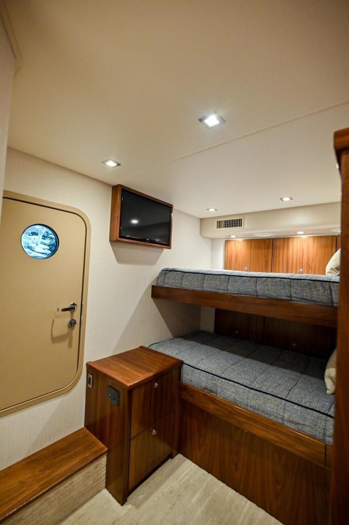 a bedroom with a bed and a tv on the wall aboard EL LOBO Yacht for Sale