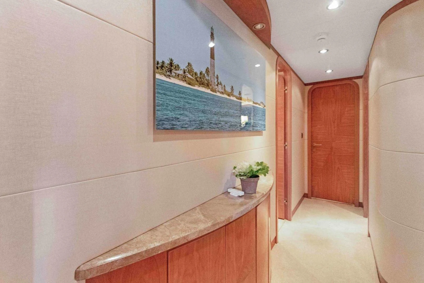 a room with a table and a window with a plant on the wall aboard B HAPPY Yacht for Sale