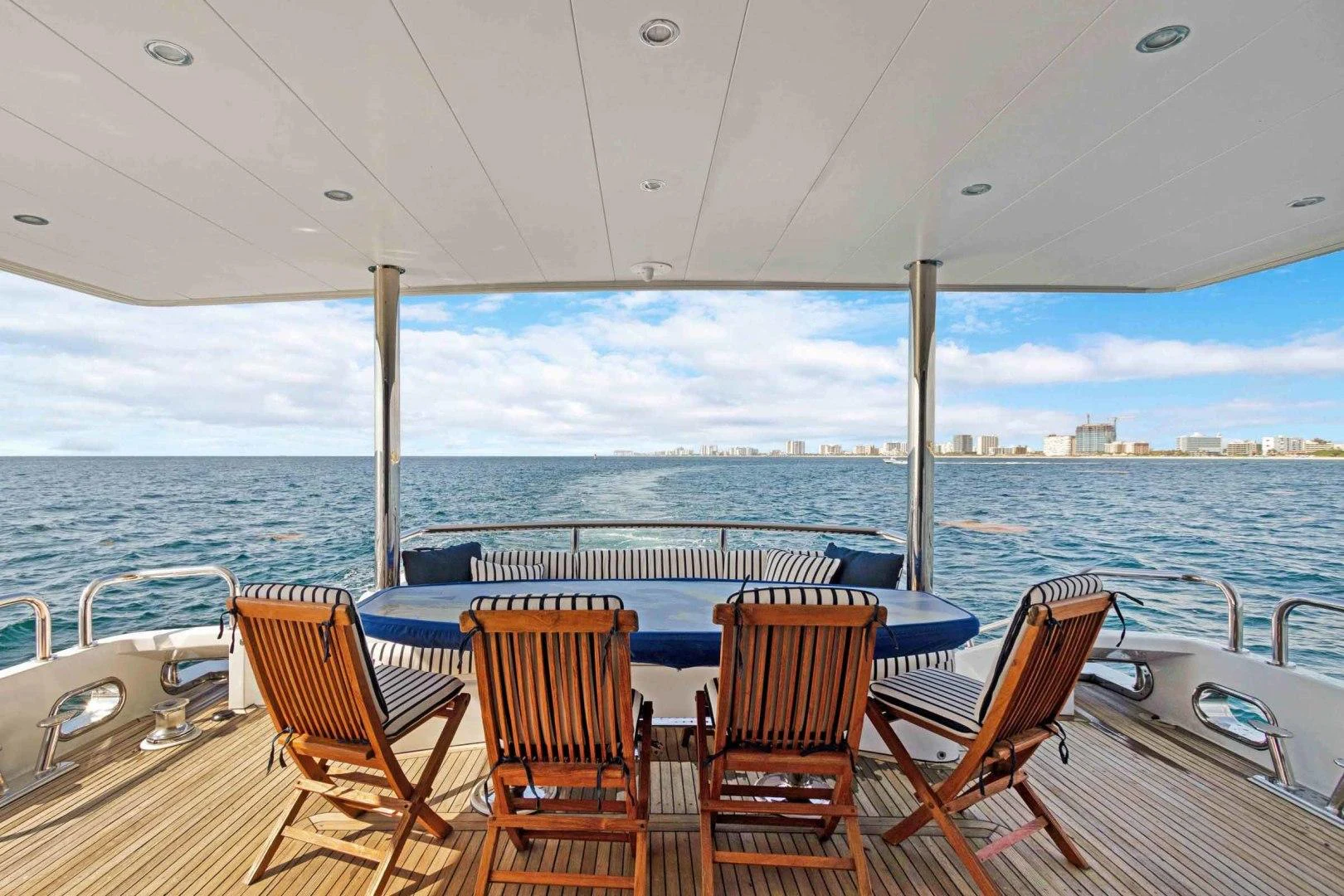 a deck with chairs on it by the ocean aboard B HAPPY Yacht for Sale
