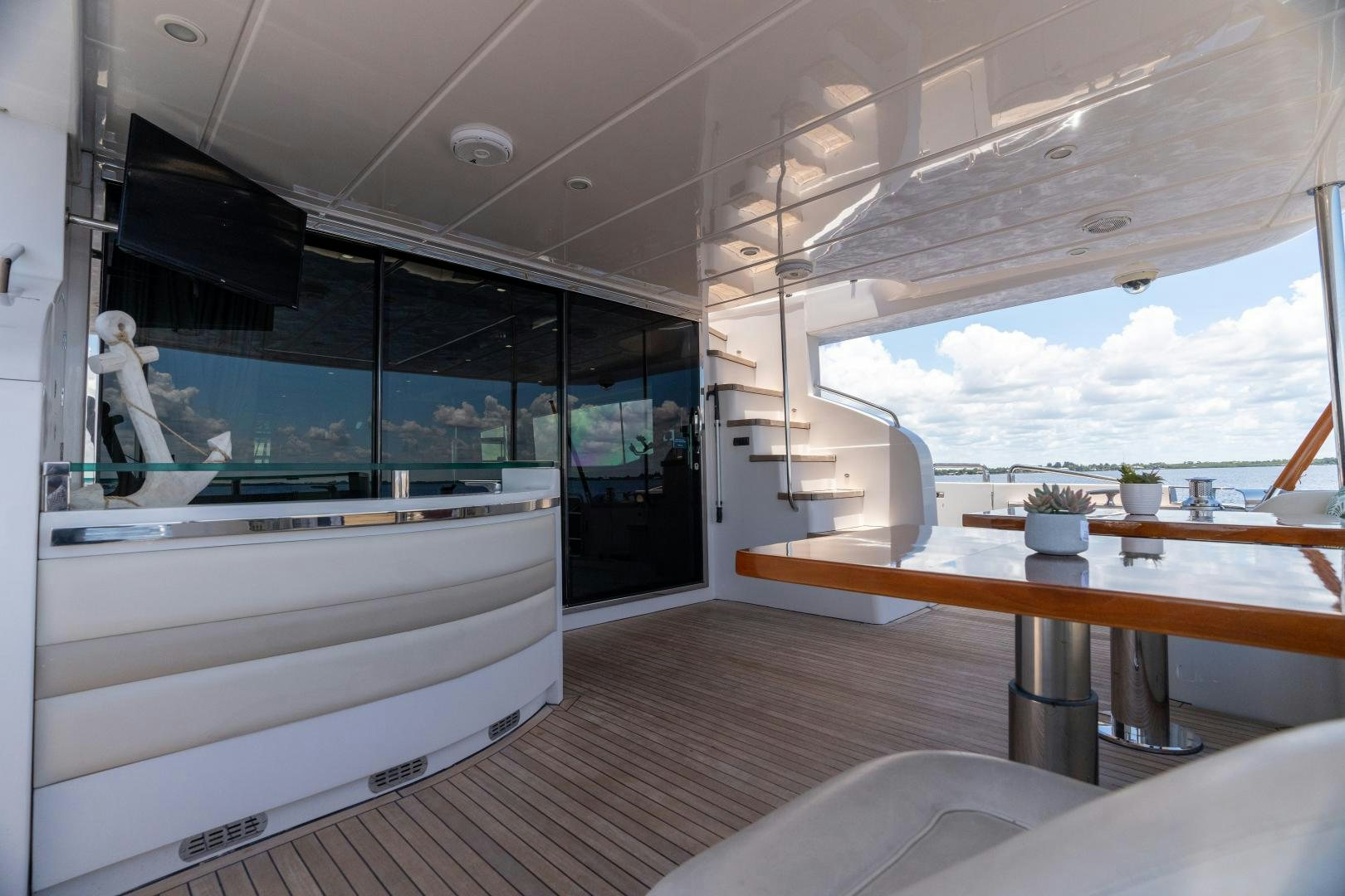 a room with a large window and a table with chairs and a view of the water aboard STEPHANIE Yacht for Sale