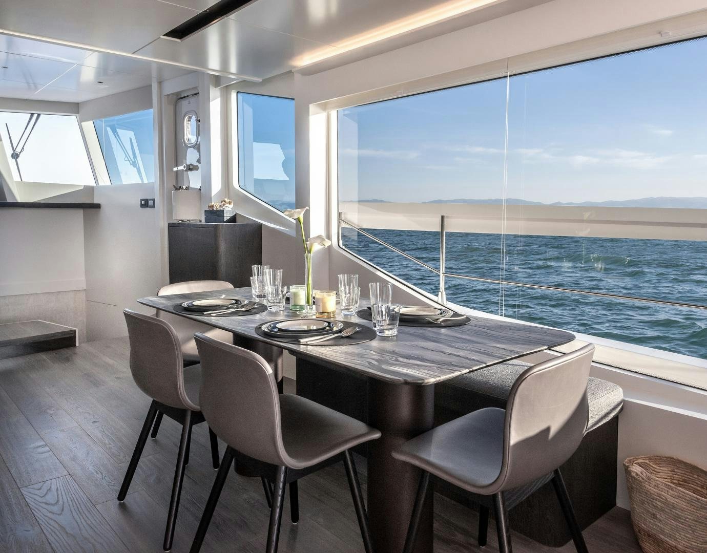 a table with chairs and a view of the ocean aboard NUMARINE 22XP Yacht for Sale