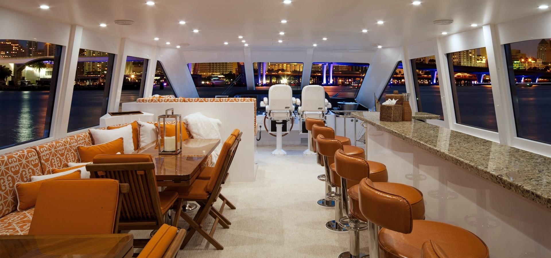 a room with tables chairs and a large window aboard ADVENTURE US II Yacht for Sale