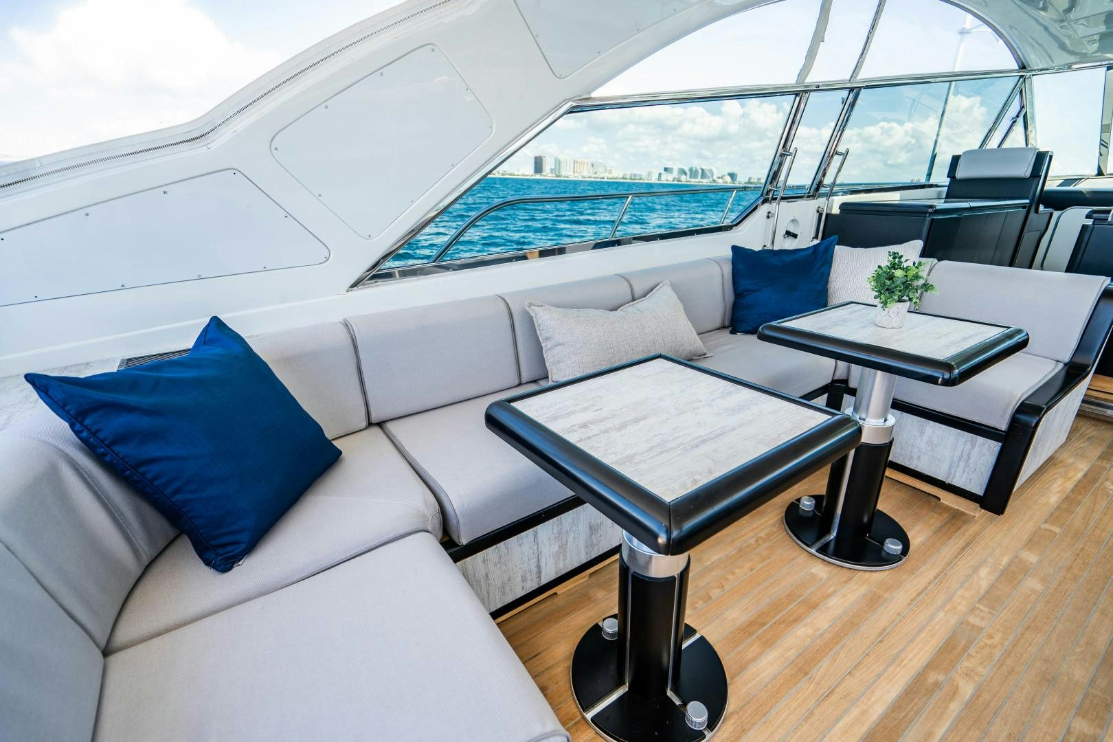 a white couch and a coffee table in a room with a large window aboard IV GIOCARE Yacht for Sale