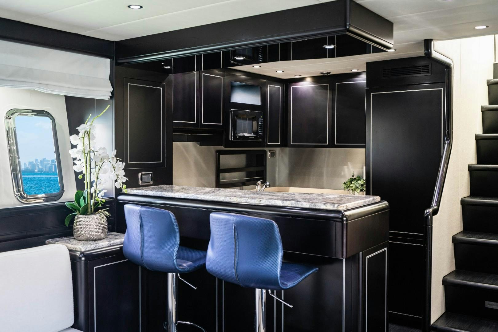 a kitchen with black cabinets aboard IV GIOCARE Yacht for Sale