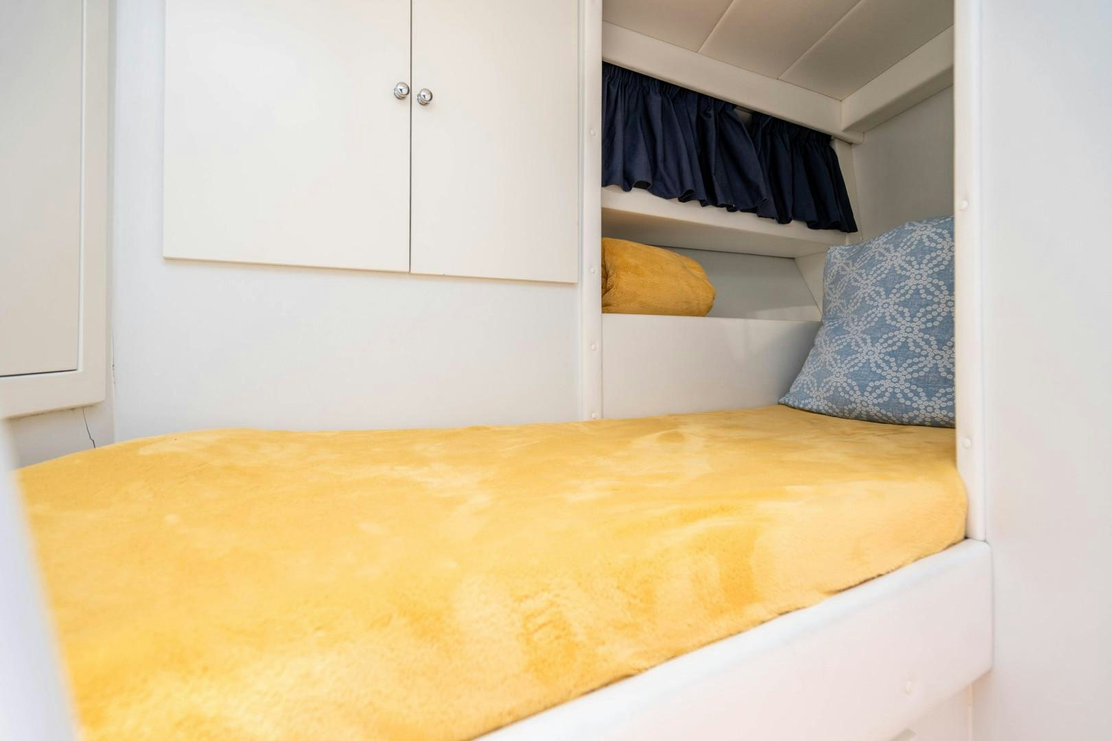 a bed with blue and white sheets aboard IV GIOCARE Yacht for Sale