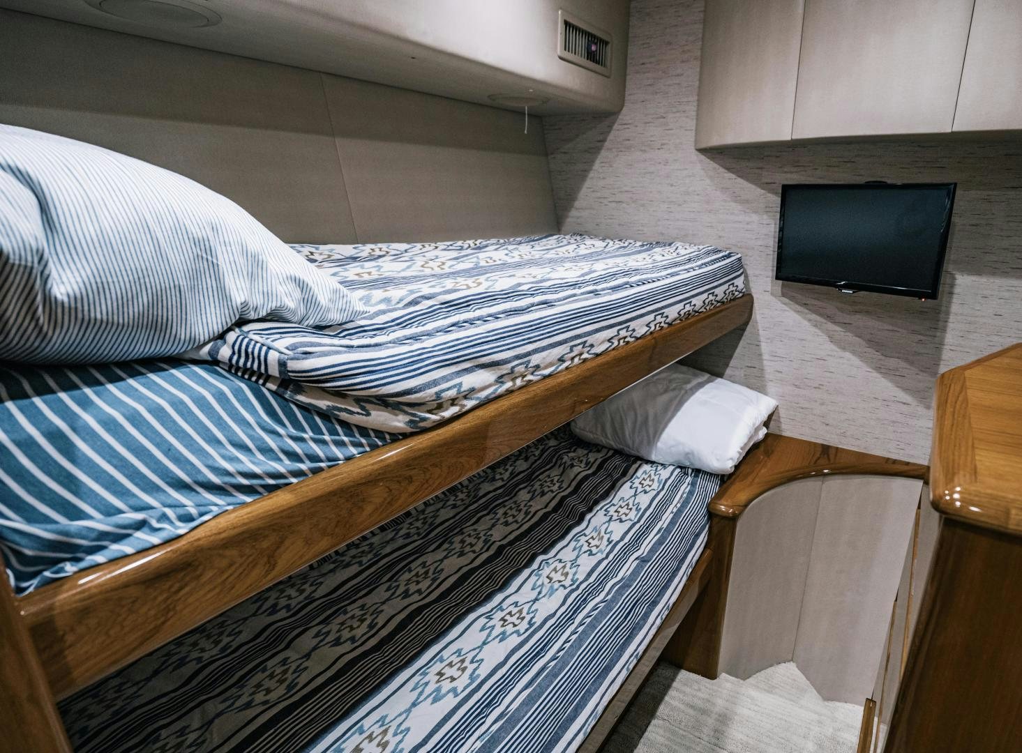 a bed with a television on the wall aboard SUNSHINE Yacht for Sale