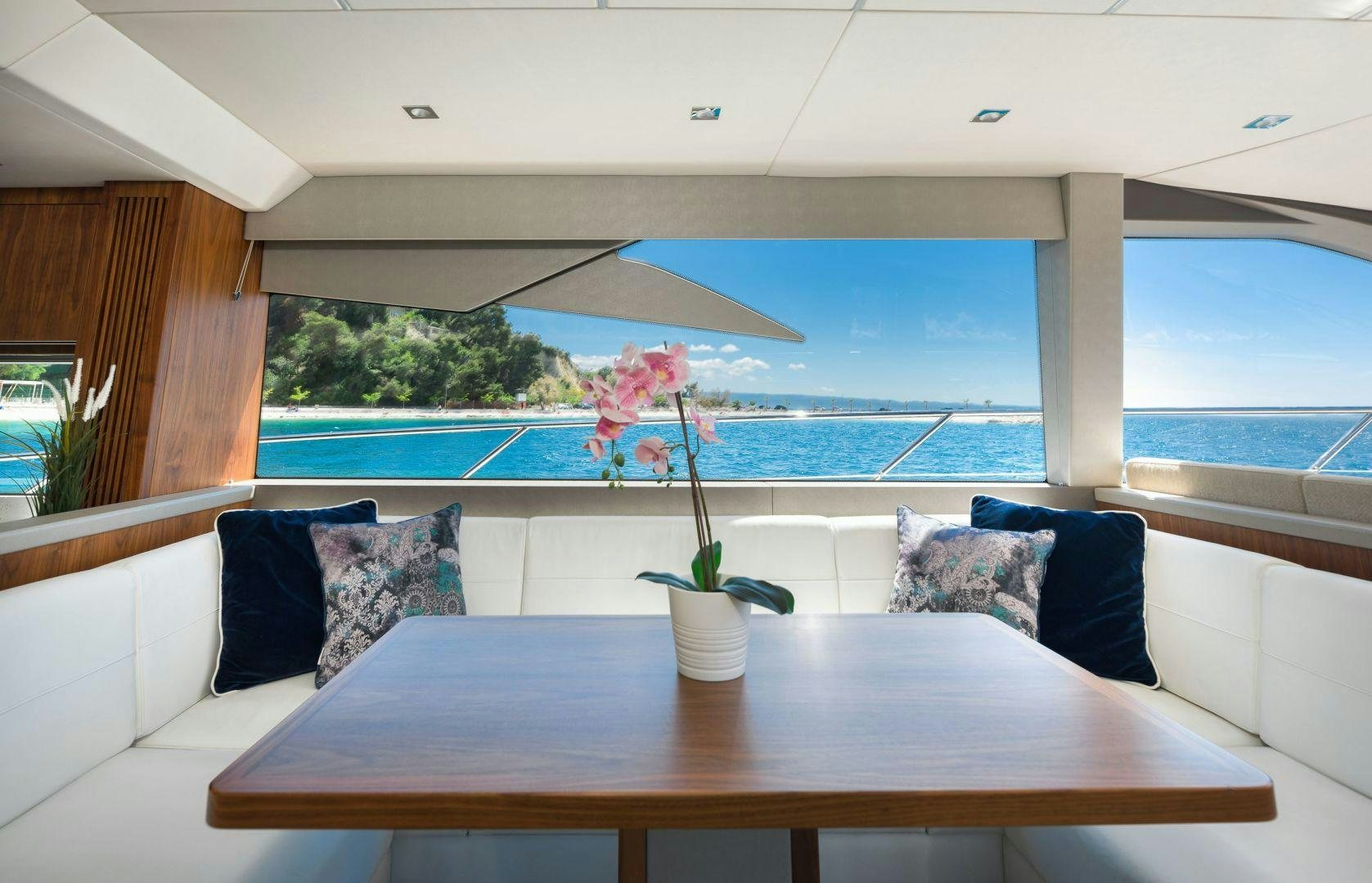 a table with pillows and a vase with flowers on it aboard HIDEAWAY Yacht for Sale