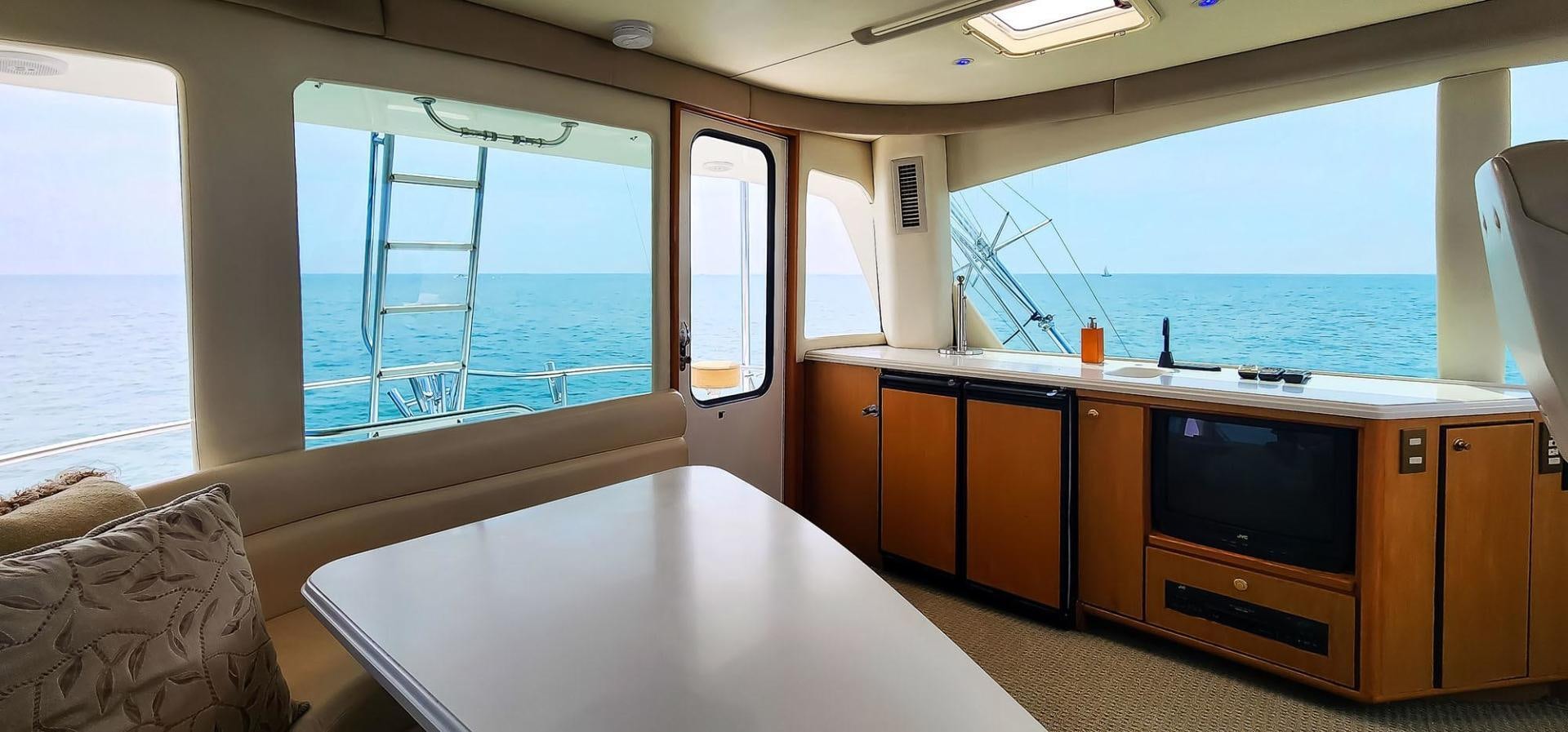 a room with a table and tv aboard My Time Yacht for Sale