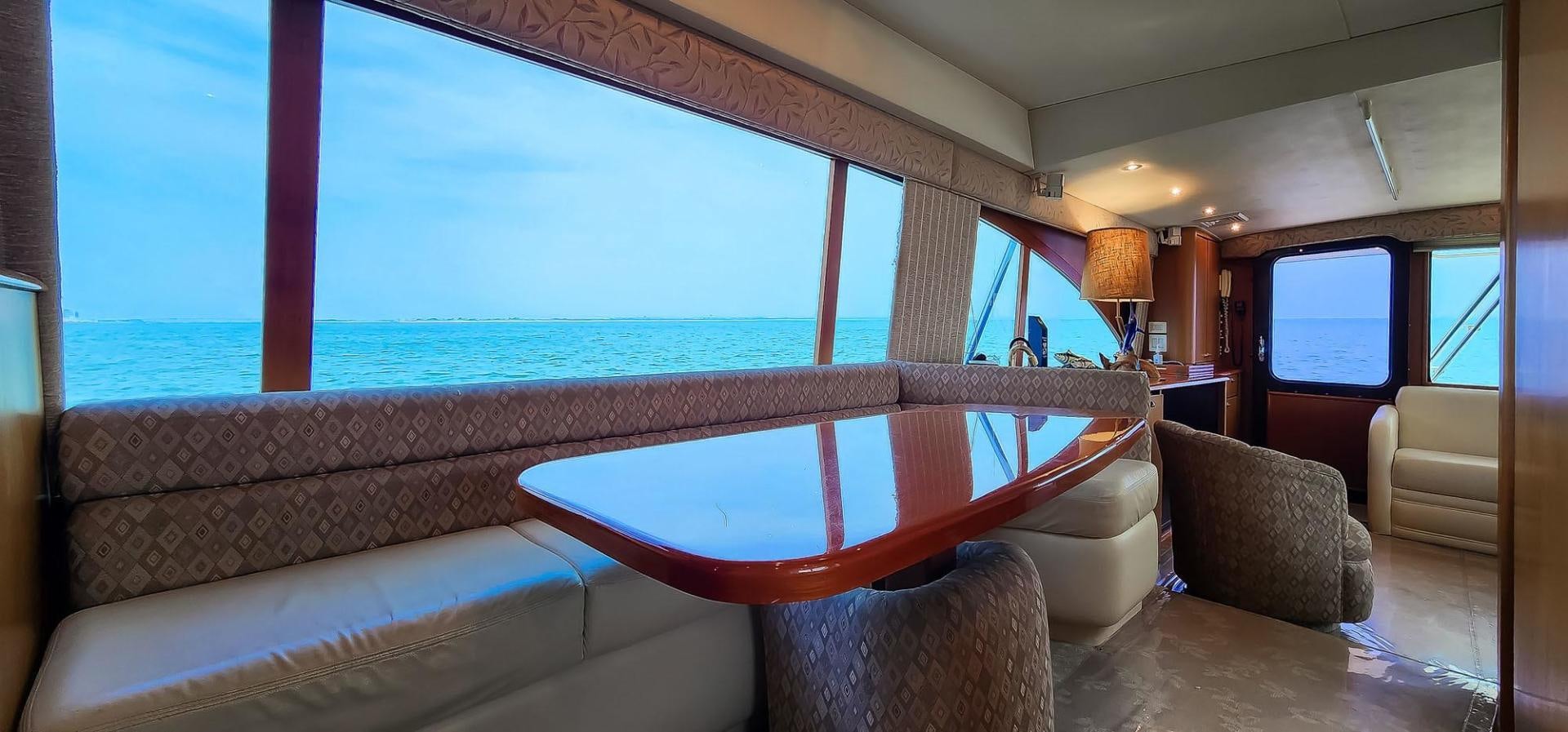 a room with a couch and a table and a large window aboard My Time Yacht for Sale