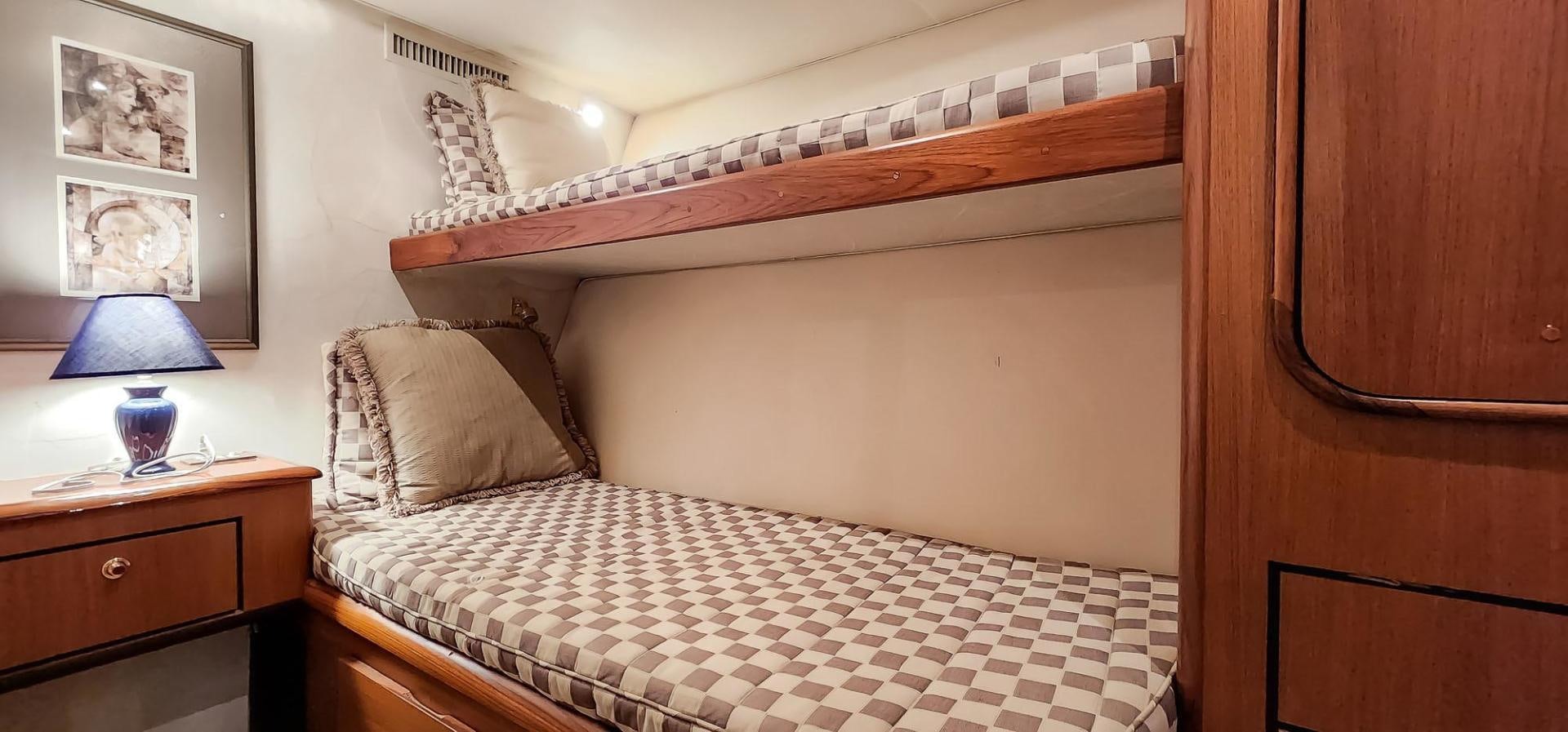a bed with a white comforter aboard My Time Yacht for Sale