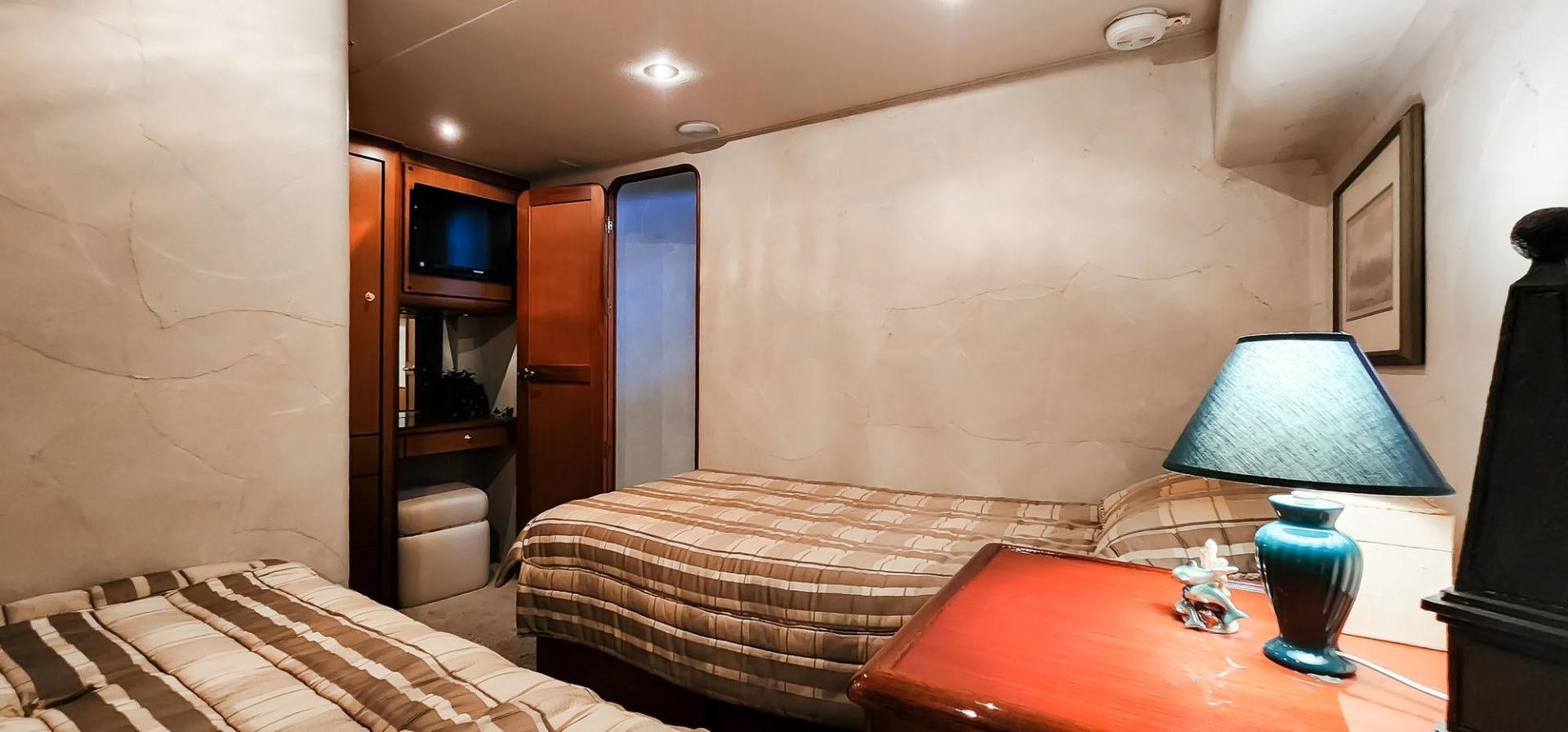 a bedroom with a bed and a lamp aboard My Time Yacht for Sale