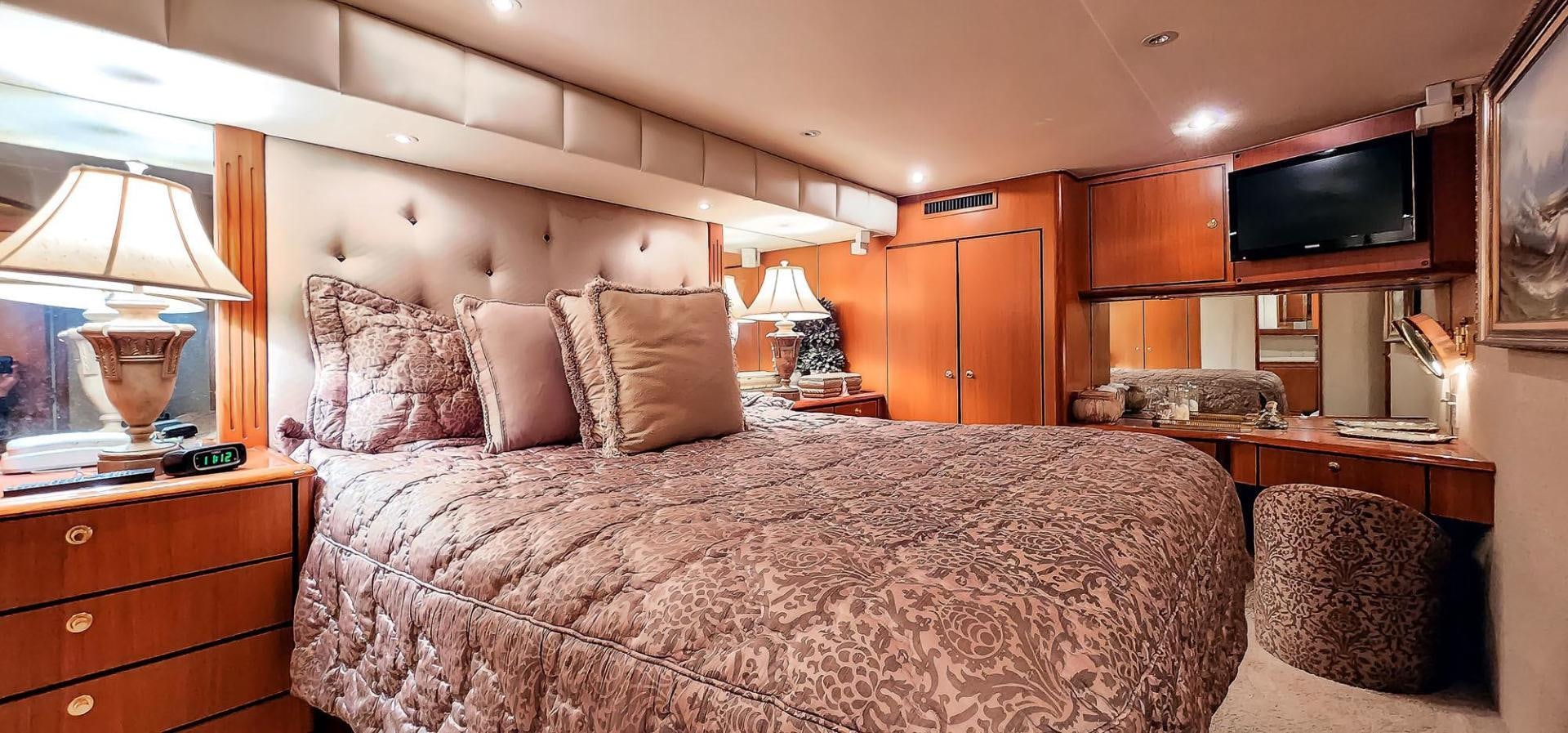 a bed with a television on the wall aboard My Time Yacht for Sale