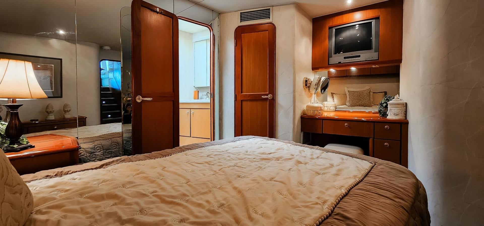 a bedroom with a bed and a television aboard My Time Yacht for Sale