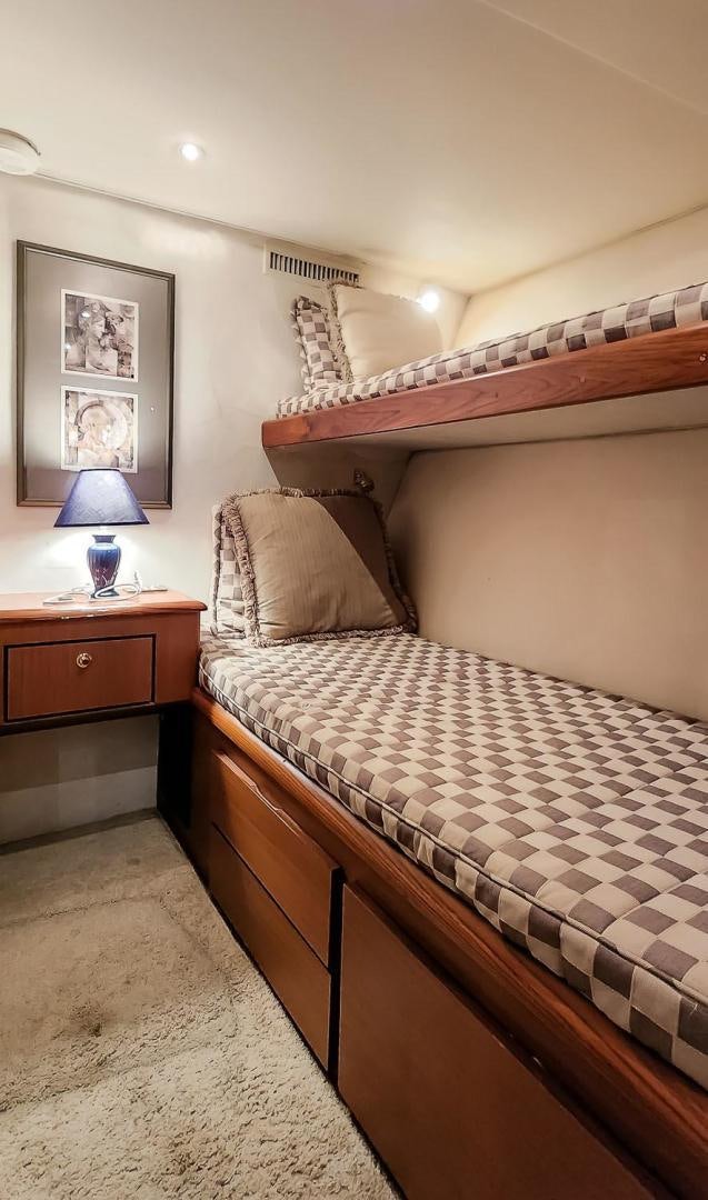 a bed with a striped comforter aboard My Time Yacht for Sale