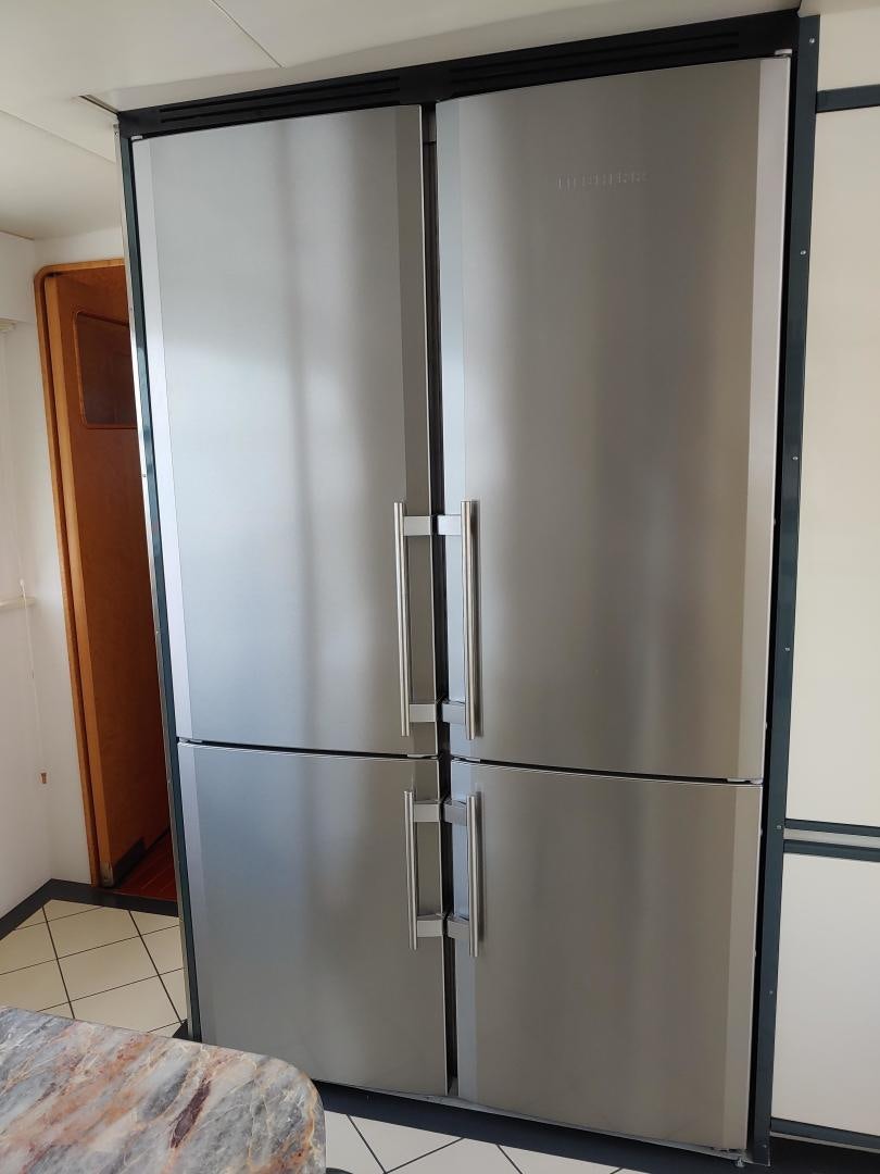 a silver refrigerator next to a black door aboard LAID BACK Yacht for Sale