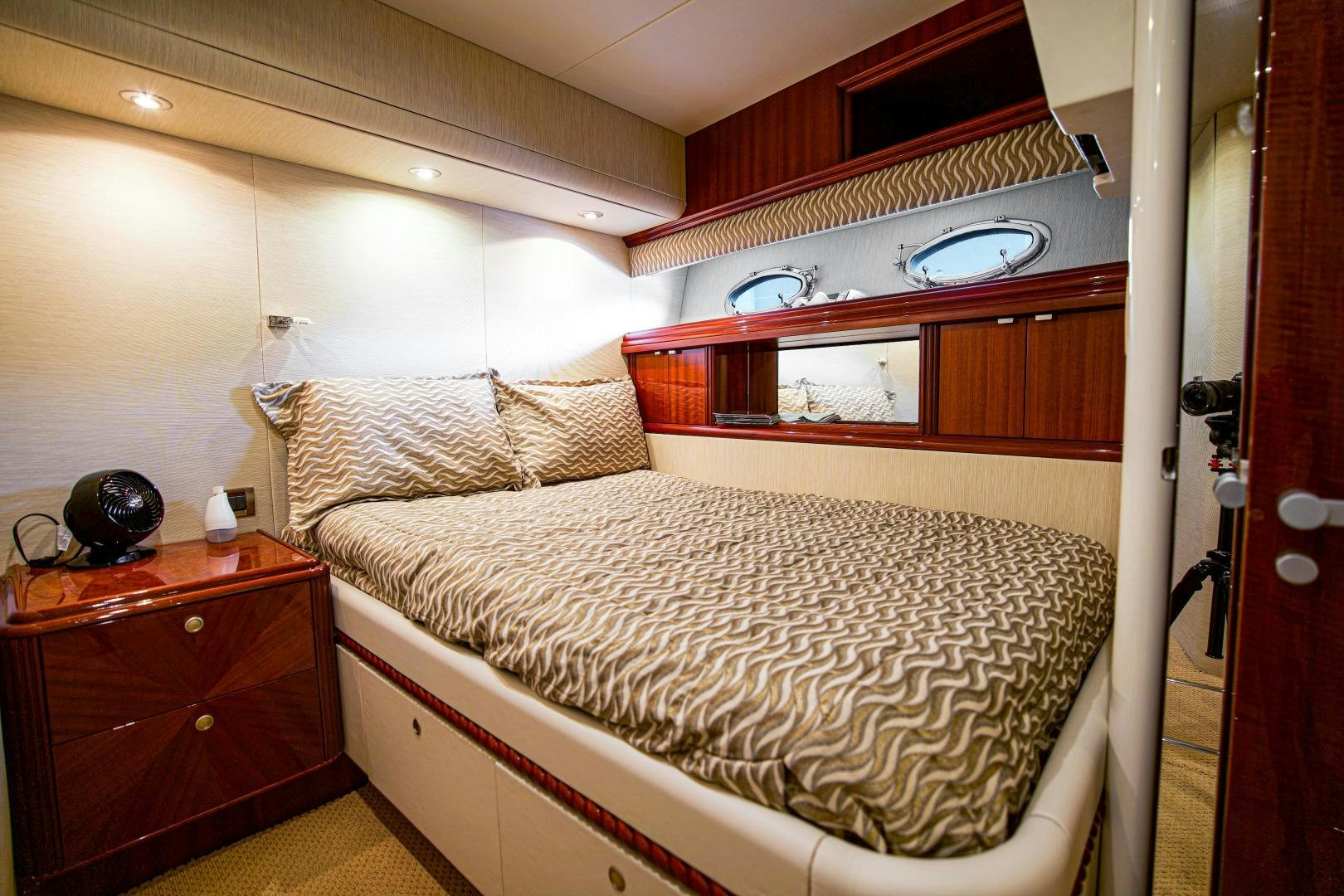 a bedroom with a bed and a dresser aboard new horizon Yacht for Sale