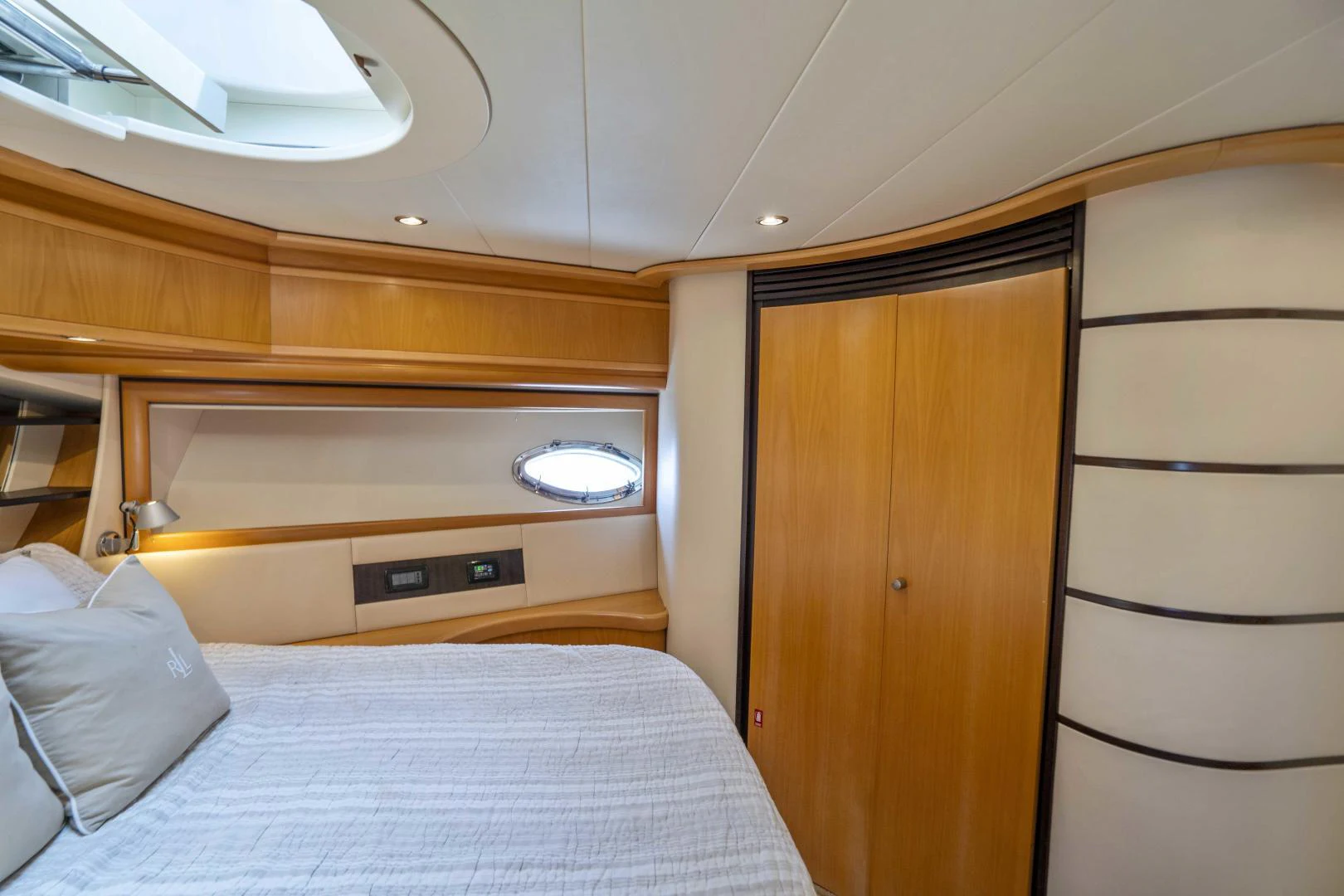 a bed with a wood cabinet aboard DENISE Yacht for Sale