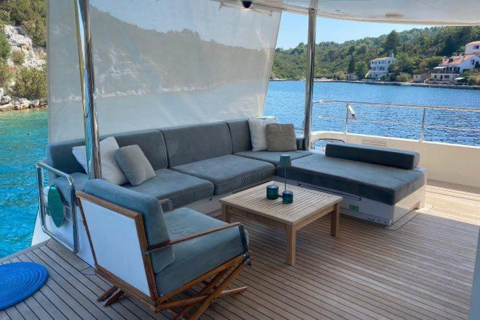 a couch and a table on a deck overlooking a body of water aboard YES Yacht for Sale