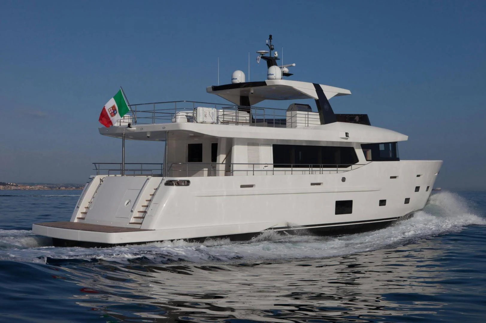 a large white boat with a flag on it aboard YES Yacht for Sale