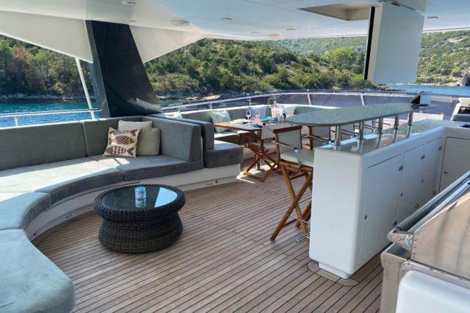 a deck with a table and chairs aboard YES Yacht for Sale