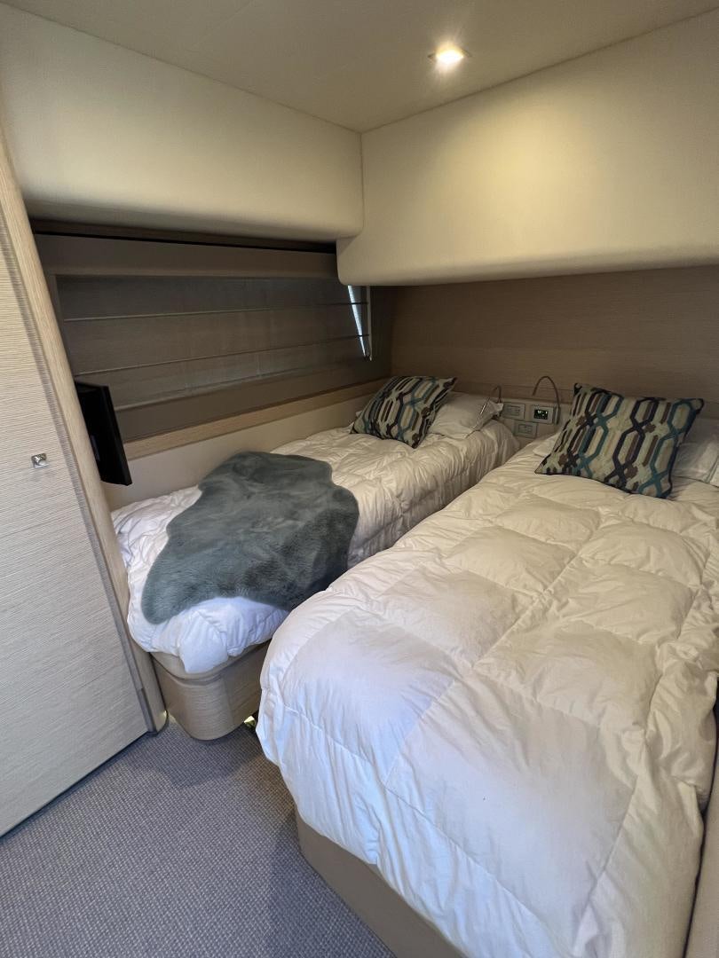 a bed with a white comforter aboard FERRETTI  Yacht for Sale