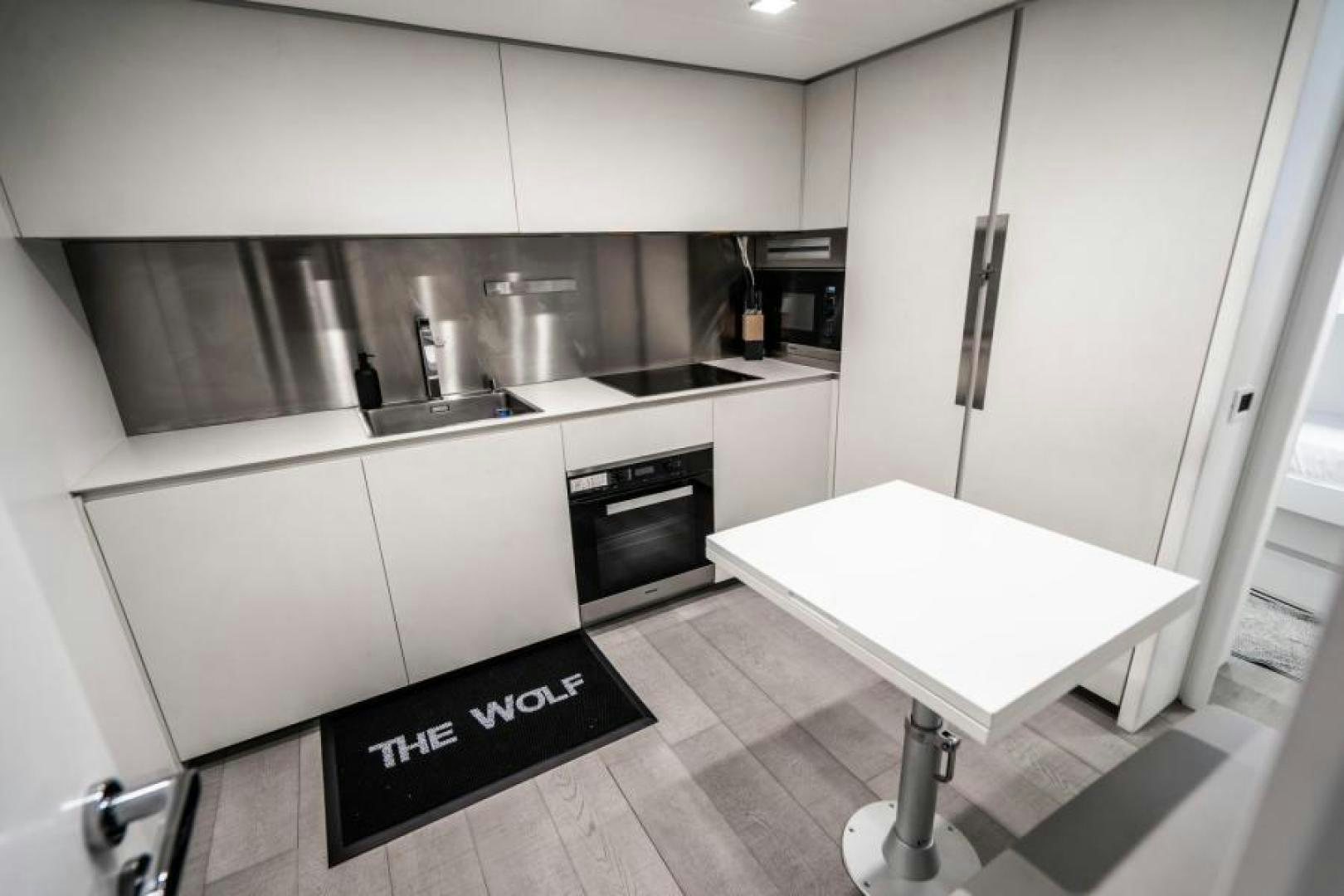 a kitchen with a table and refrigerator aboard MARCHELLY Yacht for Sale