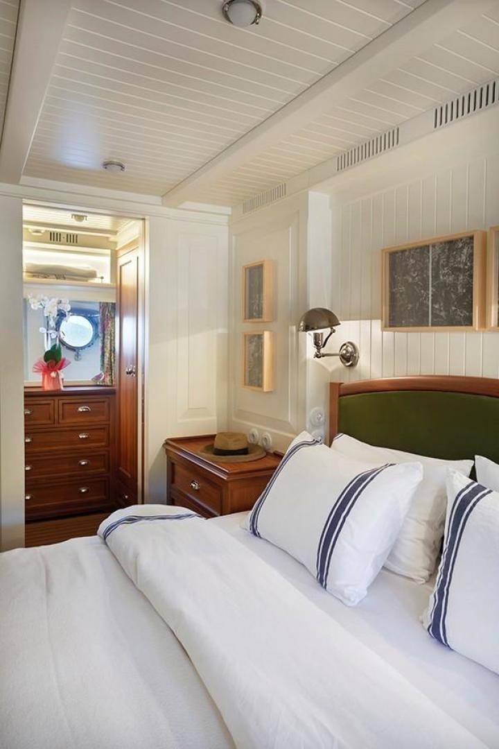 a bedroom with a bed and a mirror aboard DARWIN Yacht for Sale