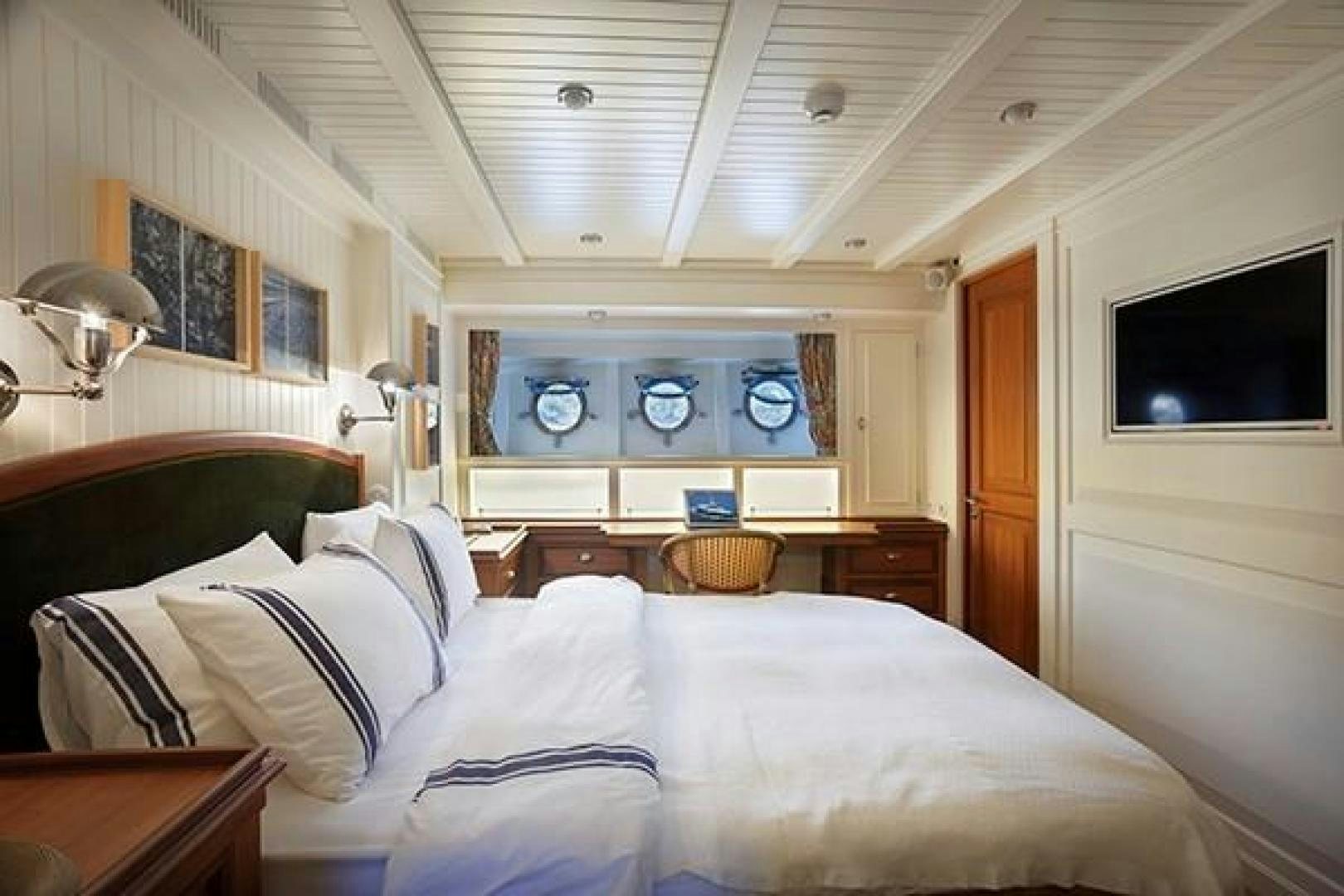 a bedroom with a bed and a television aboard DARWIN Yacht for Sale