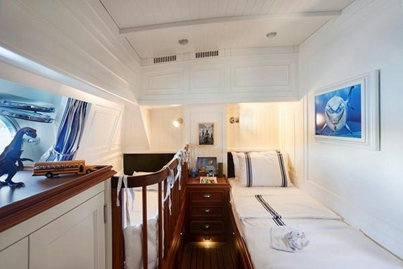 a bedroom with a bed and a desk aboard DARWIN Yacht for Sale