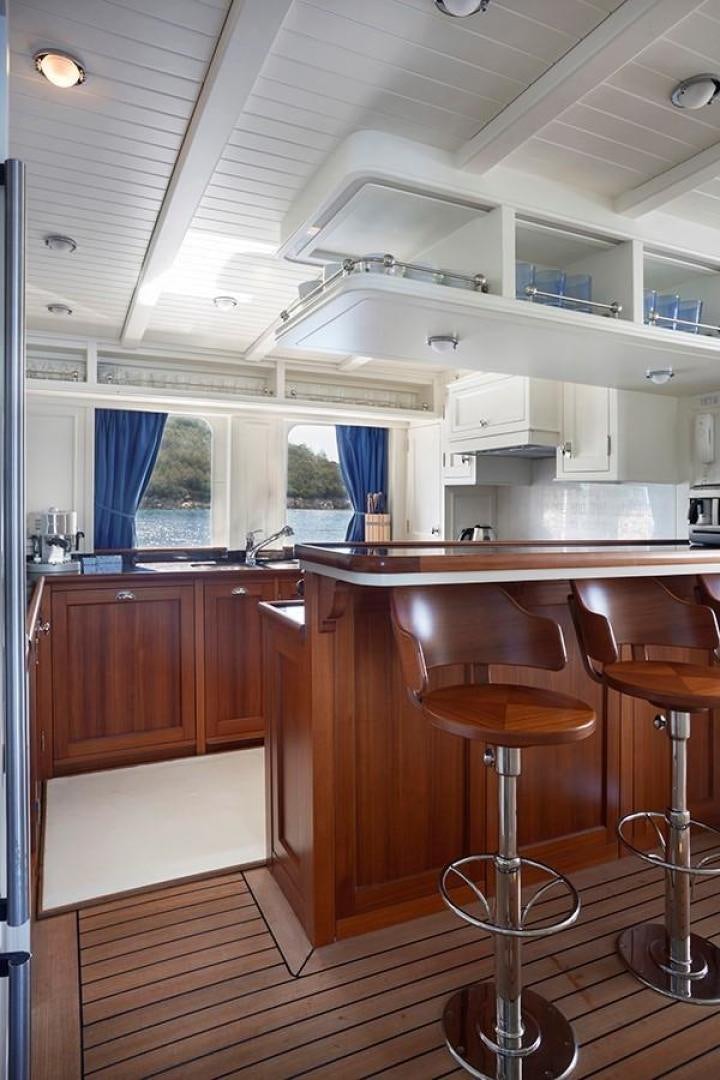 a kitchen with a bar stool aboard DARWIN Yacht for Sale