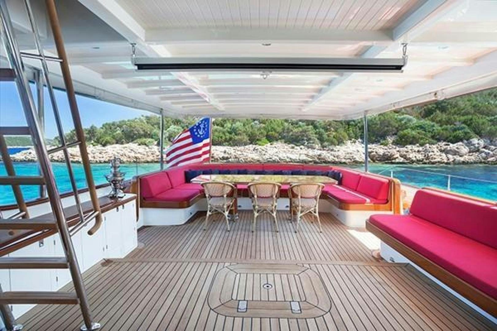 a deck with a table and chairs aboard DARWIN Yacht for Sale