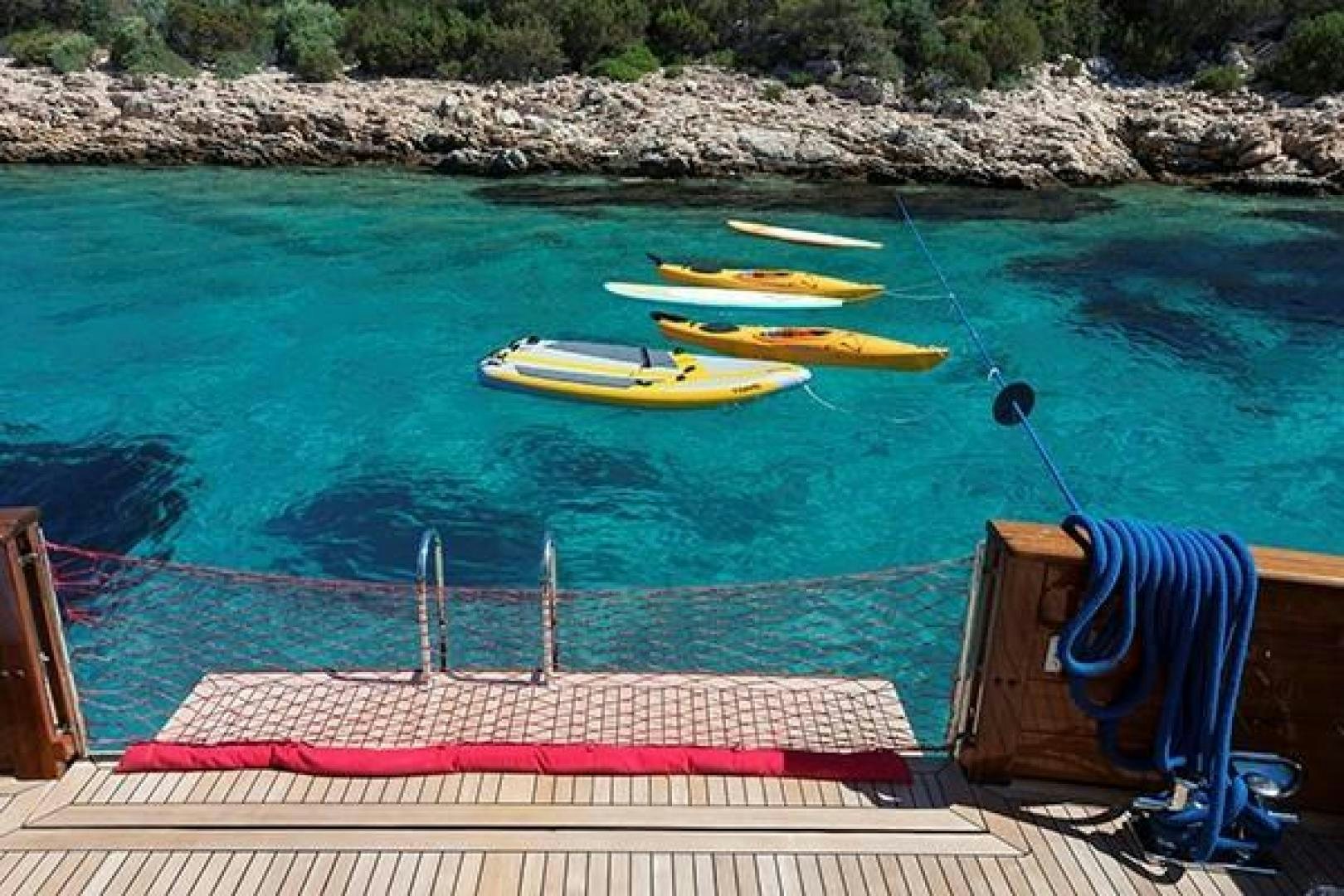 a chair and a table on a beach aboard DARWIN Yacht for Sale