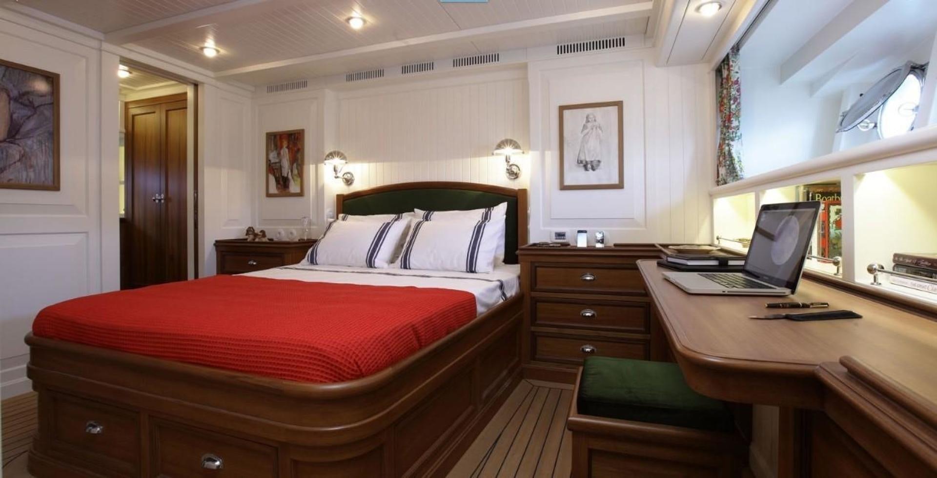 a bedroom with a laptop on the bed aboard DARWIN Yacht for Sale