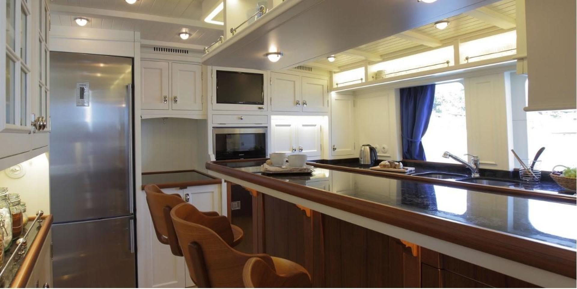 a kitchen with a fridge and microwave aboard DARWIN Yacht for Sale
