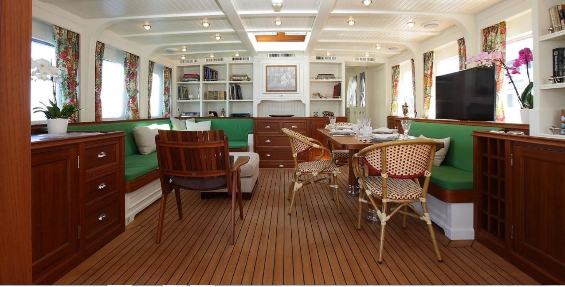 a room with a table chairs and a tv aboard DARWIN Yacht for Sale