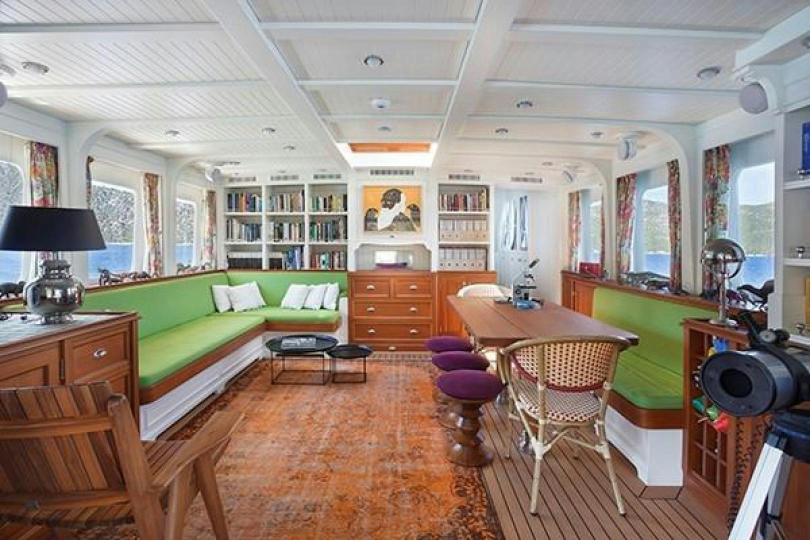 a living room with a green couch aboard DARWIN Yacht for Sale
